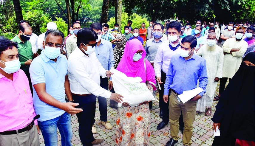 Deputy Commissioner of Bogura Zia Uddin Zia distributes food aid provided by the Prime Minister as gift for survival of the poor in the lockdown in a formal event held at the District Council Office on Monday.