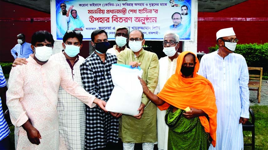 Rajshahi Mayor AHM Khairuzzaman Liton distributes food aid as Prime Minister Sheikh Hasina's gift among the hard-hit poor of the city on Sunday.