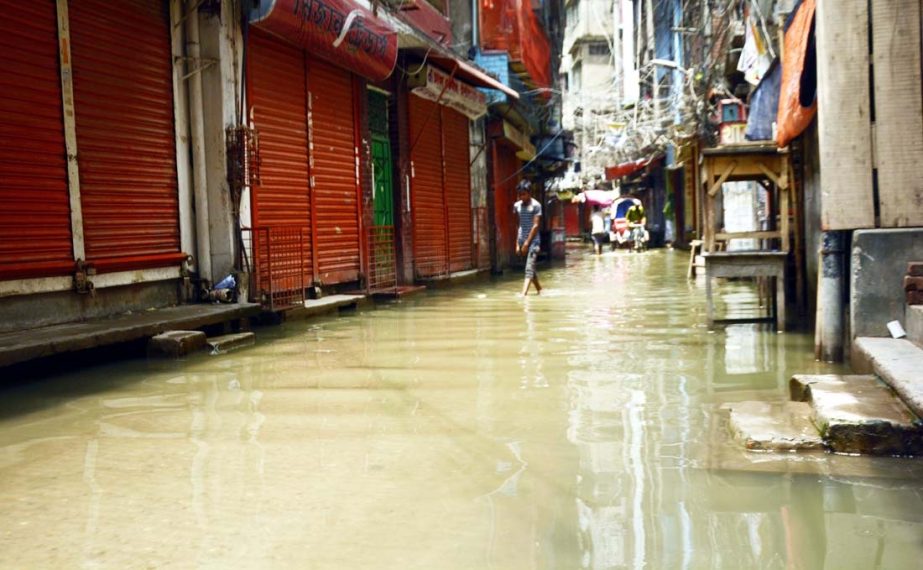 Pedestrians and passengers struggle through waterlogged street due to lack of proper drainage system. The snap was taken from the city's Siddique Bazar area on Monday.