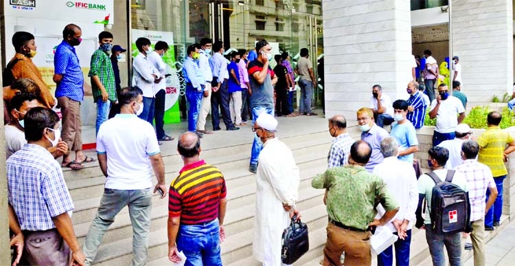 Hundreds of clients are seen standing in a long queue at the Purana Palton IFIC Branch in the capital on Monday as banks remained open till 1-30pm amid strict lockdown across the country.