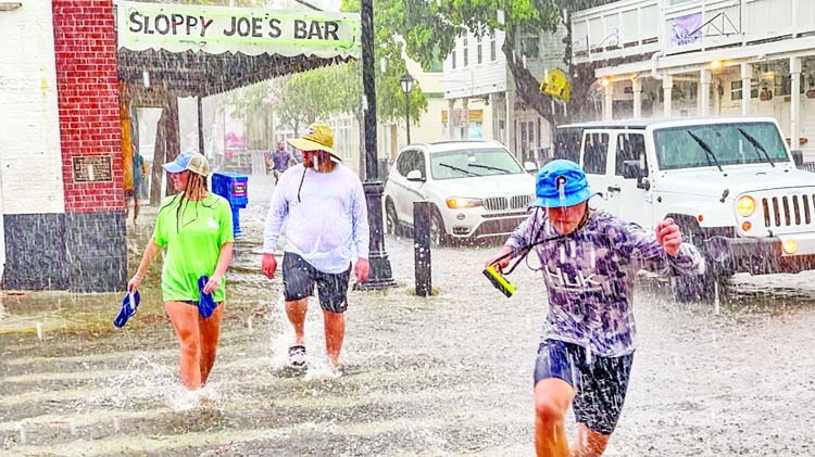 Pedestrians dash across the intersection of Greene and Duval streets as heavy winds and rain associated with Tropical Storm Elsa passes Key West, Florida, US.