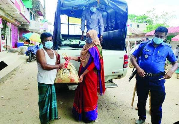 Bijoynagar Assistant Commissioner (Land) Executive Magistrate Rabia Asfar Saima distributes food aid among the local people gifted by the Prime Minister for survival of the people in the nationwide lockdown on Tuesday.