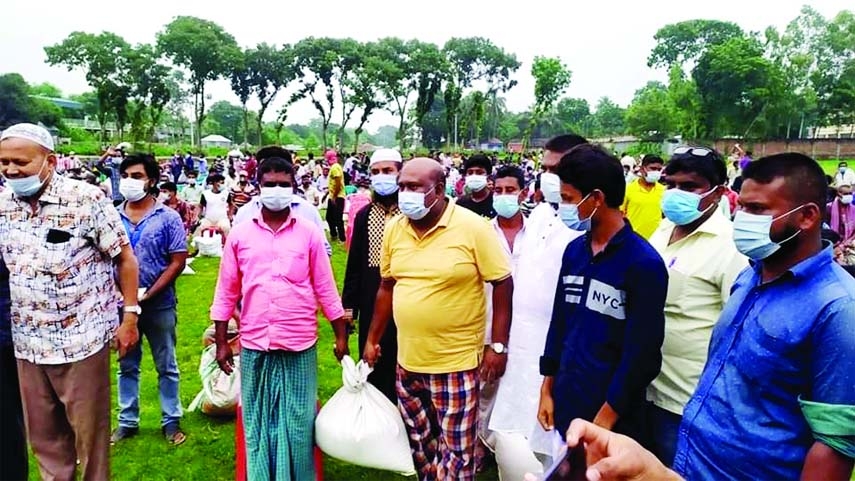 Mayor of Bhangura Municipality of Pabna, Golam Hasnain Rashel distributes food stuff among the workless auto-van drivers of the municipality on Tuesday.