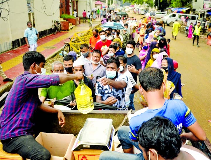 Low-income group people form a long queue to buy their daily essentials from a TCB truck in front of Bangladesh Secretariat yesterday.