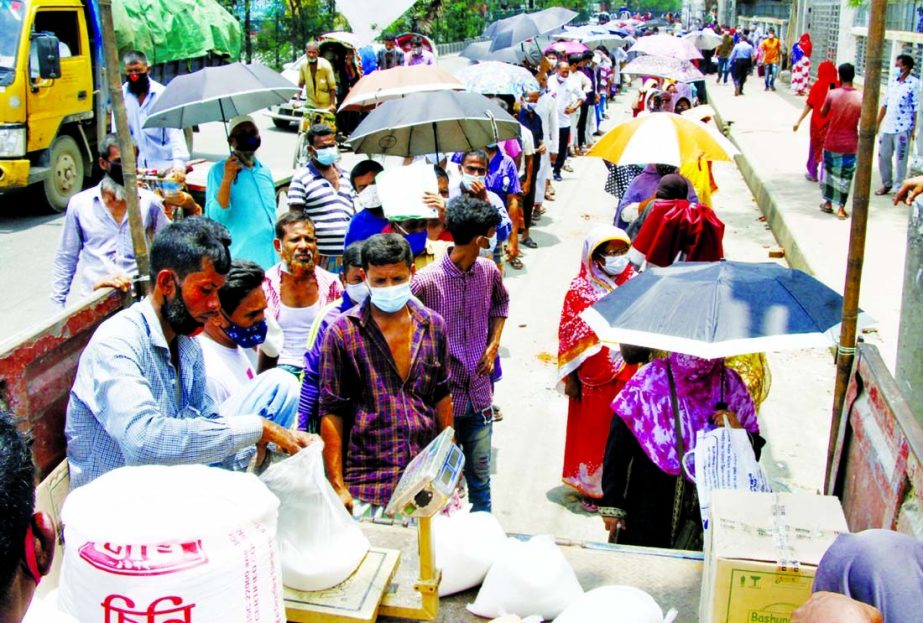 People buying sugar, lentil and oil from a TCB OMS truck in the capital's Mugda area on Thursday ignoring health protocols amid the coronavirus pandemic. The queues are getting longer.