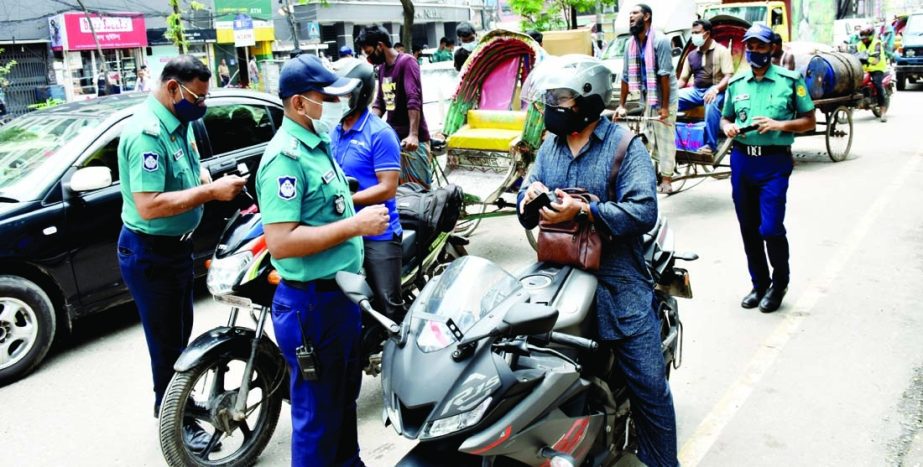 Sr. Assistant Police Commissioner of Sabujbagh Zone Monotosh Biswas and Petrol Inspector of Motijhil Zone Shahid Chowdhury supervise the commuters setting up checkpost in Motijhil area on Saturday during lockdown.