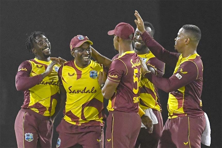 West Indies cricketers Hayden Walsh Jr. (left) and Dwayne Bravo (2nd left) celebrate the dismissal of Daniel Christian of Australia during the 1st T20I at Darren Sammy Cricket Ground on Friday.