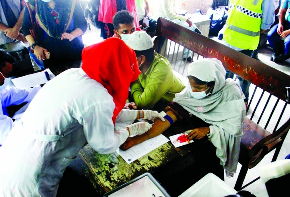 A medical staff collects blood samples from the relatives of the victims of the Narayanganj Hashem Foods Ltd factory fire for DNA testing at Dhaka Medical College Hospital on Saturday.