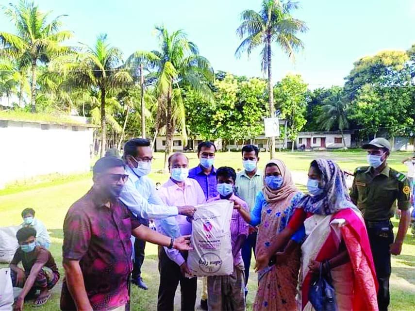 Kishoreganj Deputy Commissioner Mohamad Shamim Alam distributes food items gifted by the Prime Minister Sheikh Hasina to survive in this nationwide lockdown among 100 auto-van and rickshaws drivers in a formal ceremony at Hossionpur town on Sunday morning