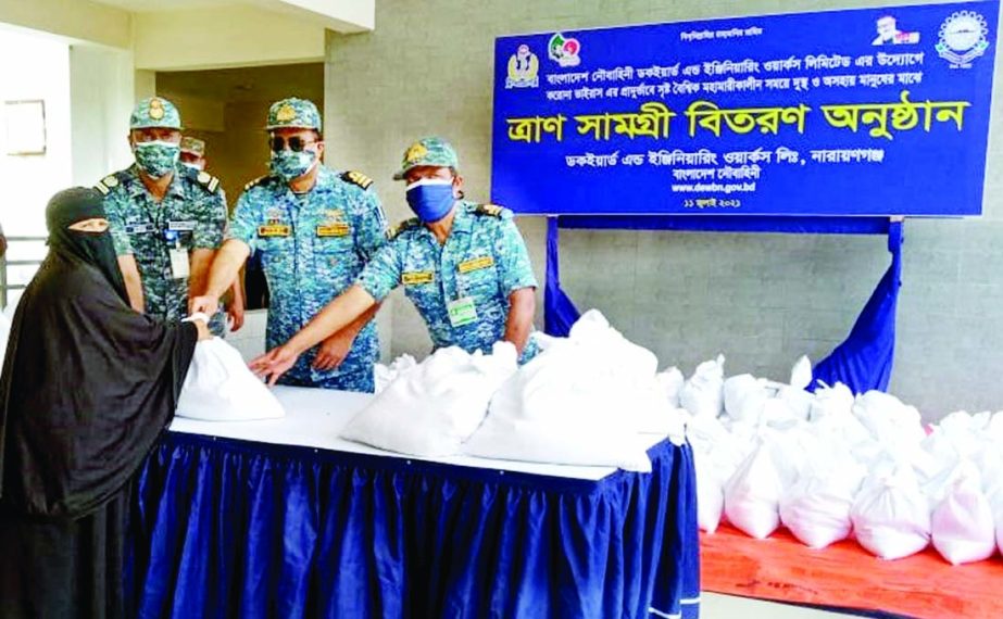 DGM (Admin) of Narayanganj Dockyard and Engineering Works Commander M Nazmul Islam gives away food aid among the local destitute people on the premises of dockyard school on Sunday. ISPR photo