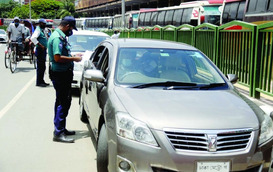 Police personnel check private cars in front of Mohakhali Bus Terminal on Sunday amid country-wide strict lockdown.