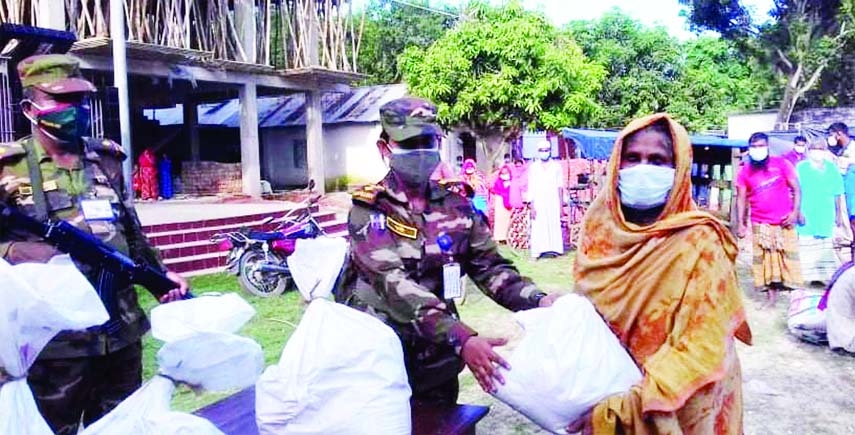 Army personnel of 10 Medium Regiment Artillery Brigade under 11 Infantry Division, Bogura Cantonment distribute food aid from their ration among the poor people of Chatmohor, Pabna at Harirumpur Union Parishad Square on Sunday. Assistant Commissioner Shar