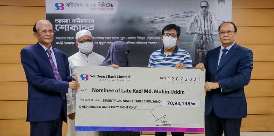 Alamgir Kabir, Chairman of Southeast Bank Limited, handing over a cheque as financial assistance to the wife of late Kazi Mohammad Mohin Uddin, who died in Corona virus recently at the bank's head office in the capital on Monday. M. Kamal Hossain, Managi