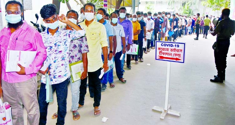 Expatriate workers stand in a queue to receive Covid-19 vaccine doses at Dhaka Medical College Hospital on Monday.