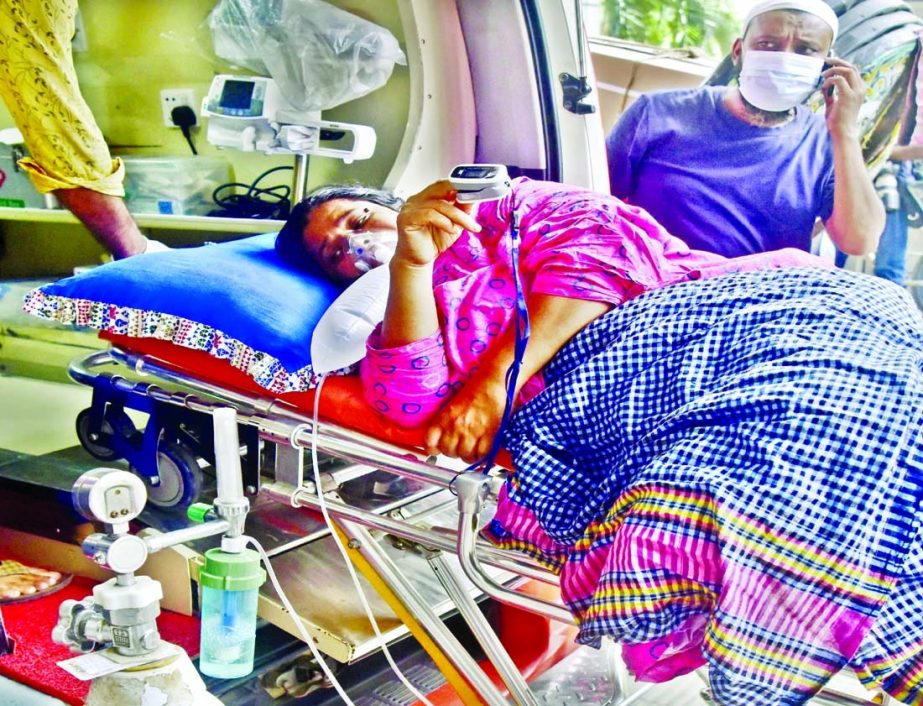 A female Covid-19 patient with to oxygen mask on face waits for admission to the Dhaka Medical College Hospital on Monday.