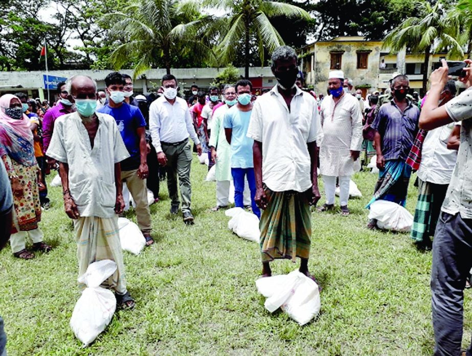 Md. Parvez Hasan, Deputy Commissioner of Shariatpur district distributes Prime Minister's food assistance among more than 700 ultra poor families at Damudya upazila ground on Tuesday. Damudya UNO Mohammad Sadikur Rahman Sabuj presided over the distributi