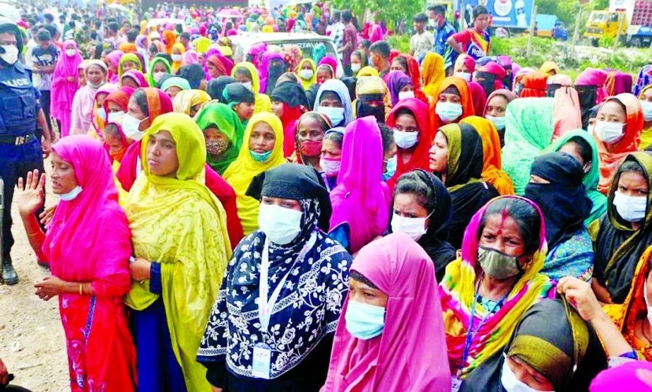 Hundreds of workers of Hashem Foods Ltd. crowd in front of its fire-ravaged factory at Rupganj in Narayanganj on Tuesday to receive their salary for June.