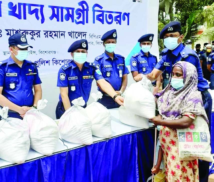 Kishoreganj Police Super Mashrukur Rahman Khaled BPM (Bar) distributes relief materials among the distressed people including people with special needs and transgenders at local Police lines playground on Wednesday.