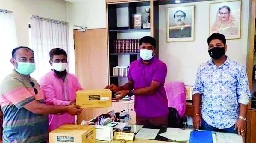 Ripon Biswas, District Council Member of Naogaon District on Tuesday hands health protection materials to Mizanur Rahman, Upazila Nirbahi Officer of Mohadebpur on behalf of the District Council.