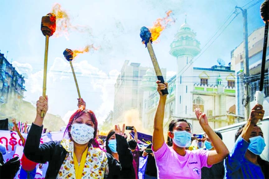 A group of women hold torches as they protest against the military coup in Yangon, Myanmar on Wednesday.