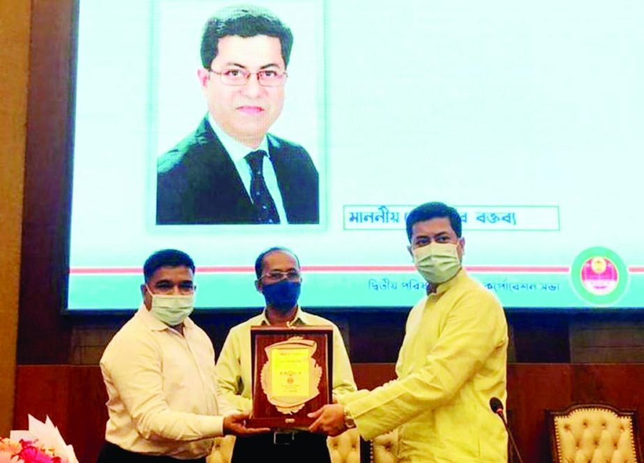 DSCC Mayor Sheikh Fazle Noor Taposh hands over integrity award to Chief Revenue Officer of the corporation Ariful Haque in Mayor Hanif Auditorium of Nagar Bhaban on Thursday.