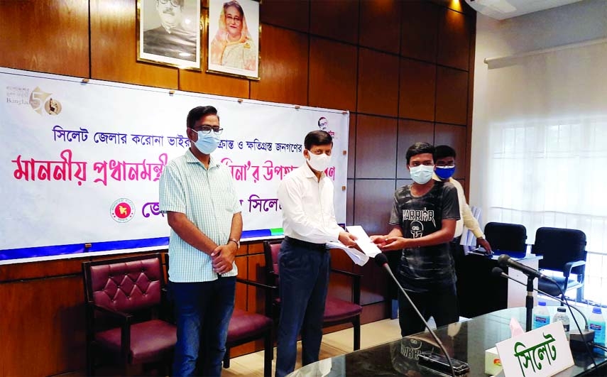 Sylhet Deputy Commissioner M Kazi Emdadul Islam hands over the Prime Minister's Eid-gifts to the office assistants of different media outlets of the district in a formal ceremony at his office on Thursday. Secretary of the Sylhet District Pres Club was p