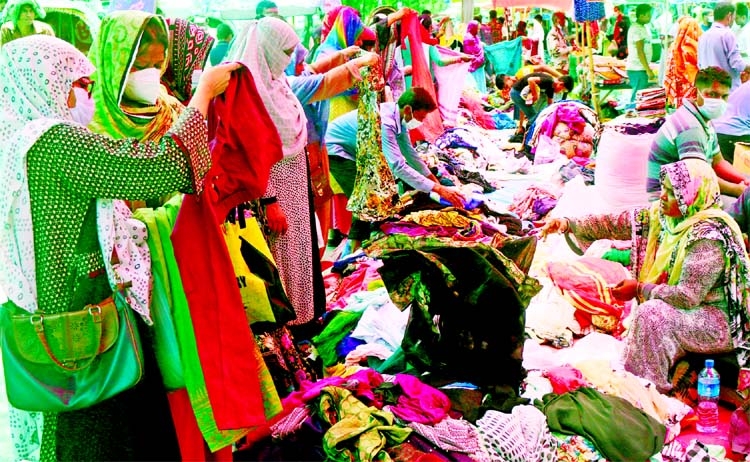 Buyers are seen selecting their clothes as holiday markets are getting momentum in front of Motijheel Ideal School on Friday on the occasion of the Holy Eid-ul-Azha.