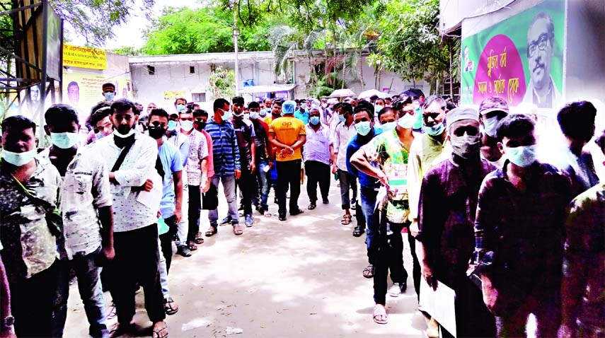 People stand in a long queue to get Covid-19 vaccine at Dhaka Medical College Hospital on Saturday as part of vaccination programme that launched across the country.