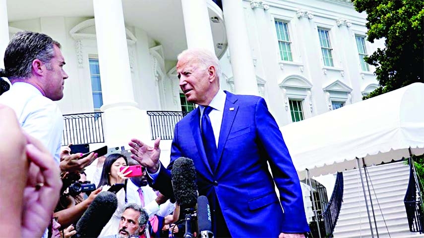 President Joe Biden talks with reporters on the South Lawn of the White House on Friday.