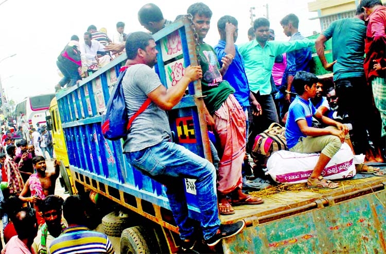 People take rides on trucks in the capital's Gabtoli area on Sunday, ignoring the life risk on their way to village homes ahead of Eid-ul-Azha.