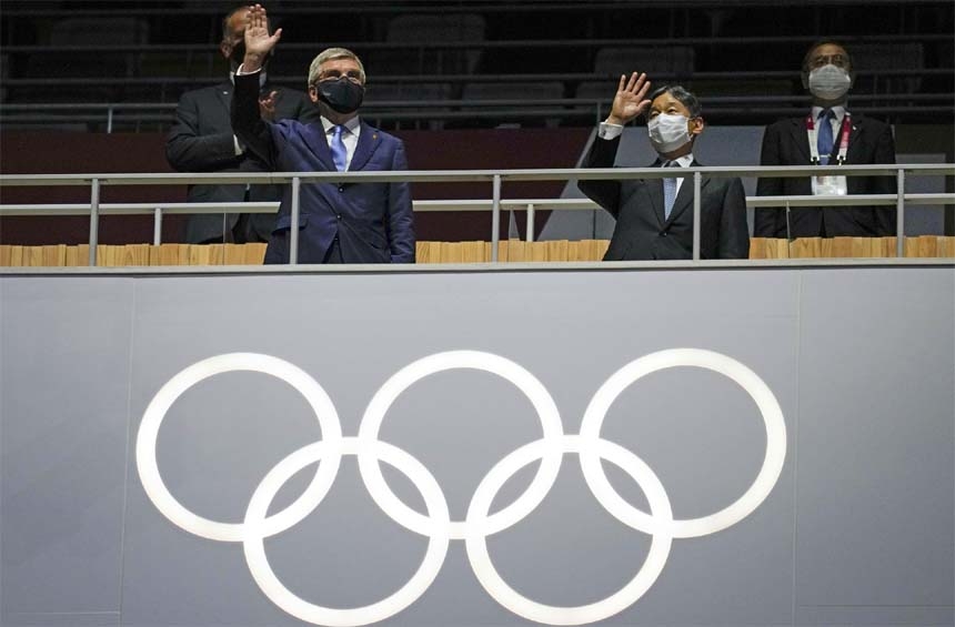 President of the IOC Thomas Bach (left) and Japan's Emperor Naruhito wave during the opening ceremony of the Tokyo Olympics at the Olympic Stadium in Tokyo on Friday.