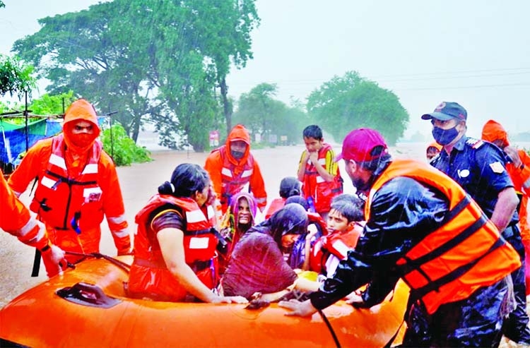 Rescue workers evacuate people from a flooded area in Kolhapur, Maharashtra, India.