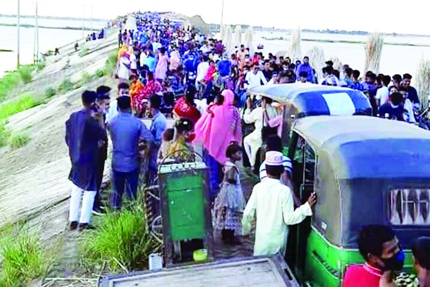 An overflowing crowd of visitors are seen on the Dhaka Road behind Naubaria village in Bhanguraupazila of Pabna. The photo was taken on Friday afternoon.