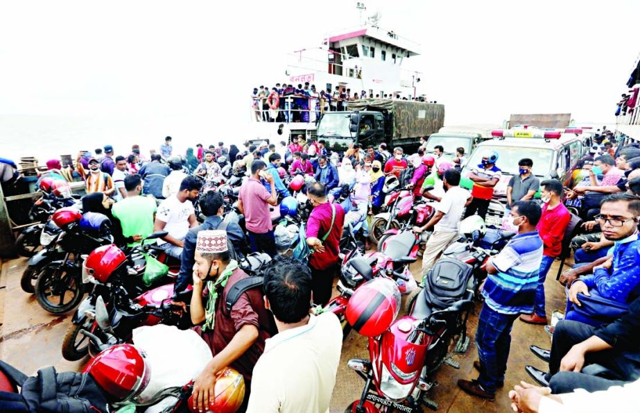 Flouting Covid health safety guidelines, passengers cram into a ferry on their way back to Dhaka on Saturday.