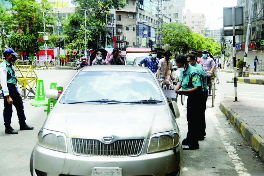Police personnel check the papers from a private car in front of Bata Signal at Elephant Road in the capital on Sunday on the third day of lockdown after Eid.