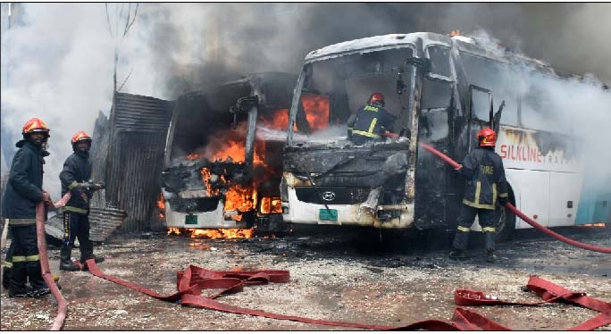 Fire fighters douse fire from two buses as they were ablaze behind Bangladesh Bank colony at Motijheel area in the capital on Sunday.