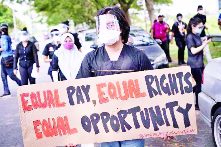 A contract doctor holds a placard during a strike outside the Sungai Buloh Hospital in Selangor state on Monday, as junior doctors staged walkouts at several hospitals protesting against poor conditions, even as Malaysia faces a worsening coronavirus outb