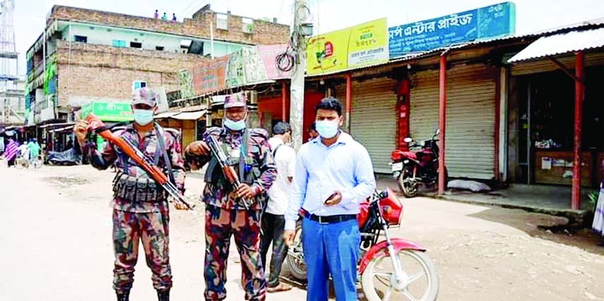 Collectorate Executive Magistrate of Kishoreganj Obidur Rahman Sahel is seen patrolling with BGB members to implement the nation-wide lockdown in various hat bazaars in Pakundia Upazila on Monday.