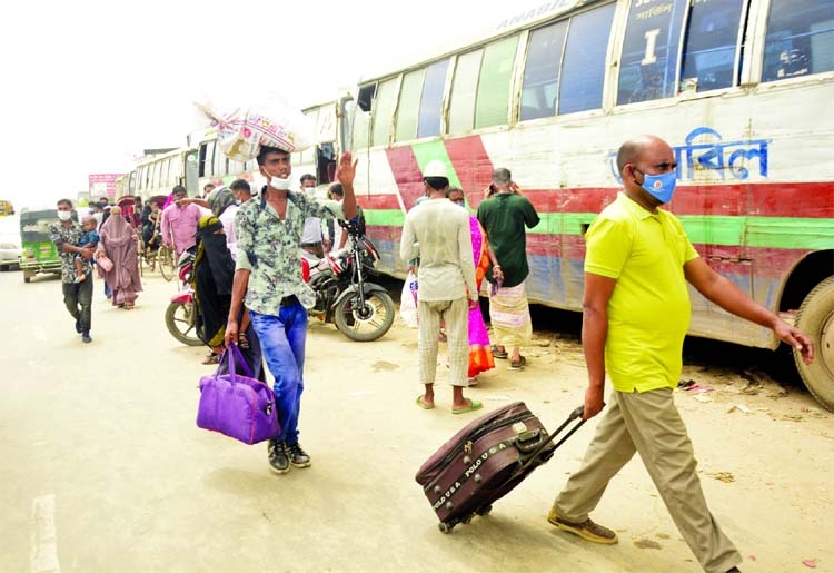 People come to the capital on foot at Sanarpar area on the Dhaka-Chattogram Highway on Monday as public transport stopped due to strict lockdown.