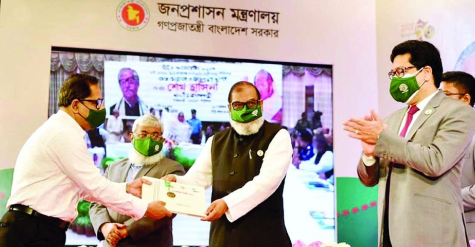 Liberation War Affairs Minister AKM Mozammel Haque hands over Public Administration Medal-2021 to Information and Broadcasting Secretrary Mokbul Hossain at Osmani Memorial Auditorium in the city on Tuesday. Prime Minister Sheikh Hasina joined the programm
