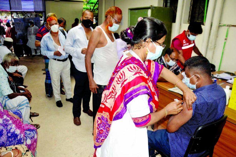 People wait in a queue for a shot of the first dose of vaccine against Covid-19 in Dhaka on Tuesday.