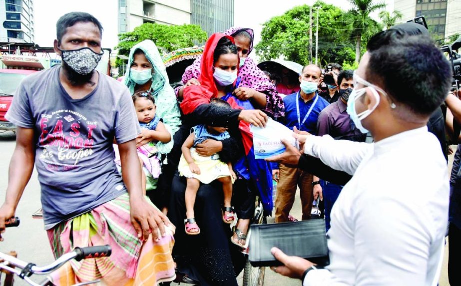 Commuters being given masks free of cost setting up check-post by RAB. The snap was taken from the city's Motijheel on Wednesday.