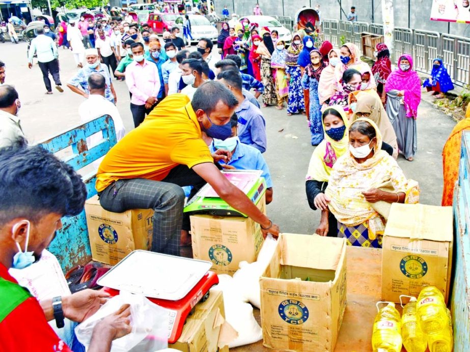 People are seen standing in a long queue for TCB OMS products at Motijheel area in the capital on Wednesday.
