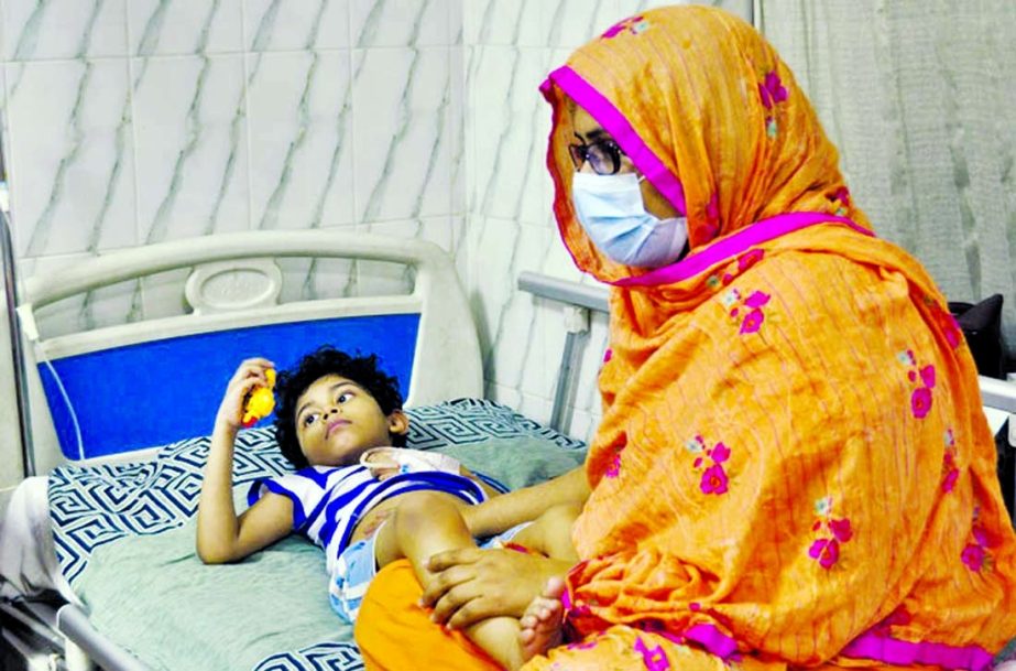 An anxious mother sits beside her dengue-affected child at Holy Family Hospital in Dhaka on Thursday.