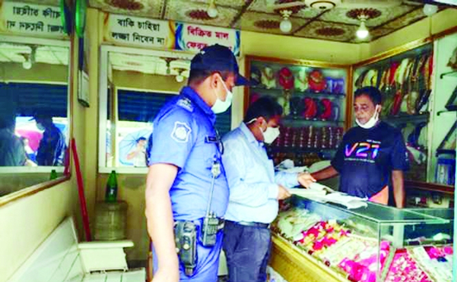 Kalapara Executive Magistrate Upazila Assistant Commissioner (Land) Jagoth Chandro Mondal leads a mobile court at the coastal town of Kalapara, Patuakhali and fines different shops for violating lockdown norms on Wednesday