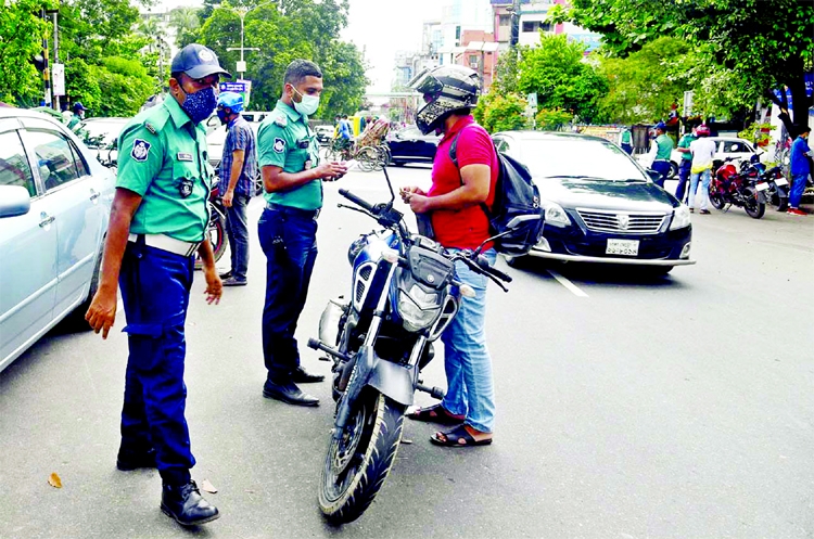 Police remains in vigil to check the commuters during lockdowe with a view to resisting corona pandemic. The snap was taken from Dhanmondi 32 in the city on Friday.