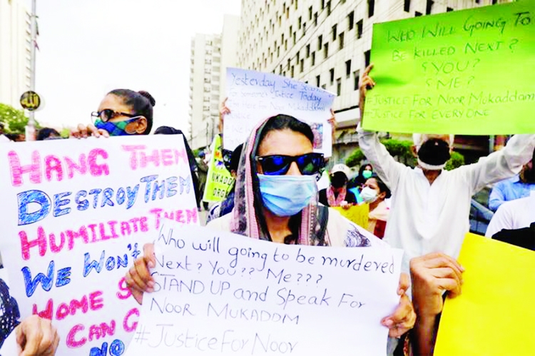 People carry signs to condemn the violence against women and girls during a protest in Karachi, Pakistan.
