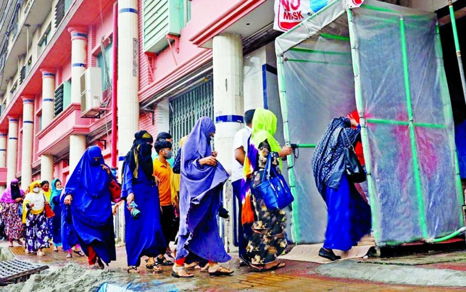 Garment workers pass through a disinfection tunnel to enter a factory in the capital's Kamalapur area on Sunday.