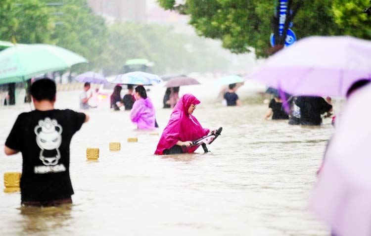 Residents wade through floodwaters on a flooded road amid heavy rainfall in Zhengzhou, Henan province, China.