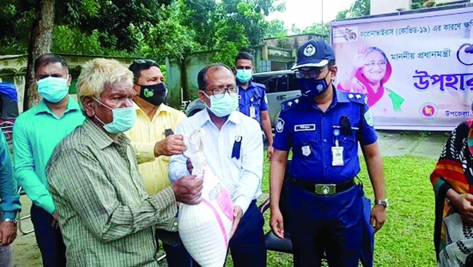 Deputy Commissioner of Panchagarh, Md. Johurul Islam distributes food aid as Prime Minister's gift among 300 transport workers of the district at Sadar upazila parishad in compliance with health guidelines on Tuesday. Superintended of Police Md. Yousuf A